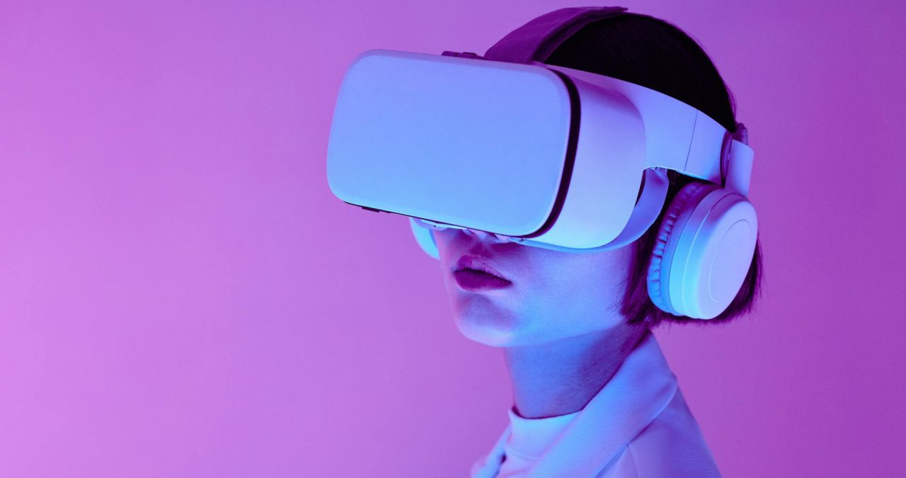 How to Use Ai Ai benifits in our daily life A TrendSnip user immersed in a virtual reality experience, wearing a VR headset and over-ear headphones, against a striking purple backdrop. Their light-colored outfit is bathed in soft, colorful lighting, evoking a futuristic and captivating ambiance.